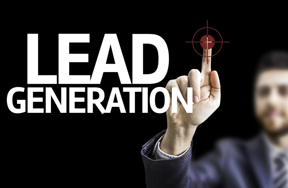 Business man pointing to black board with text Lead Generation